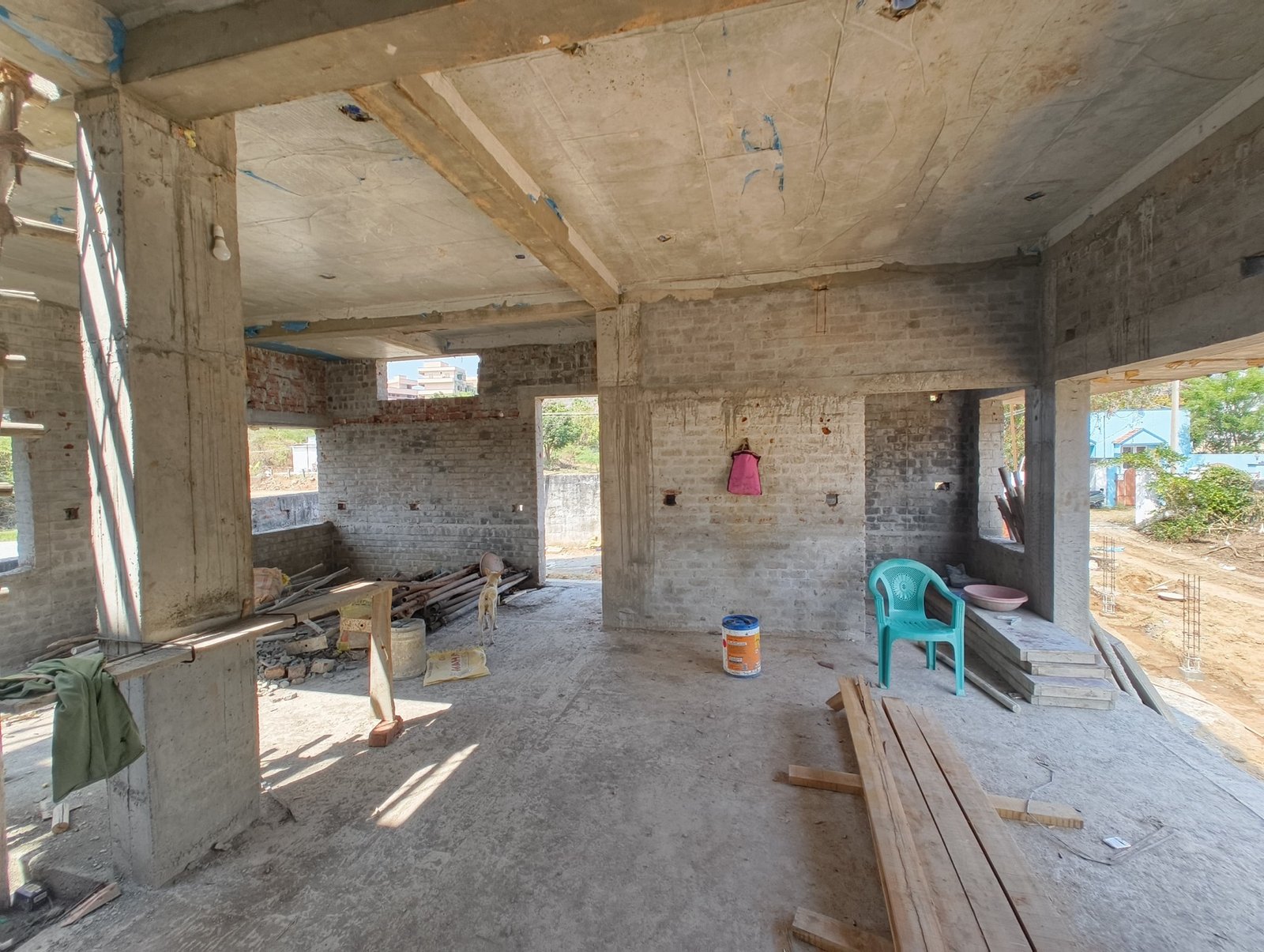 The house under construction, an open concrete frame with wide openings to the garden